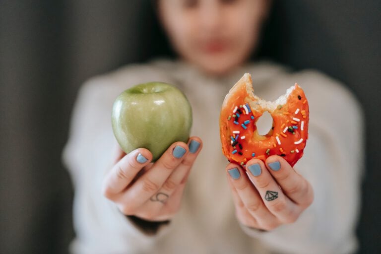 Frau mit Apfel und Süßigkeit in der Hand